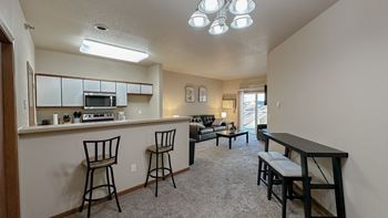 the view of a living room with a bar and a kitchen